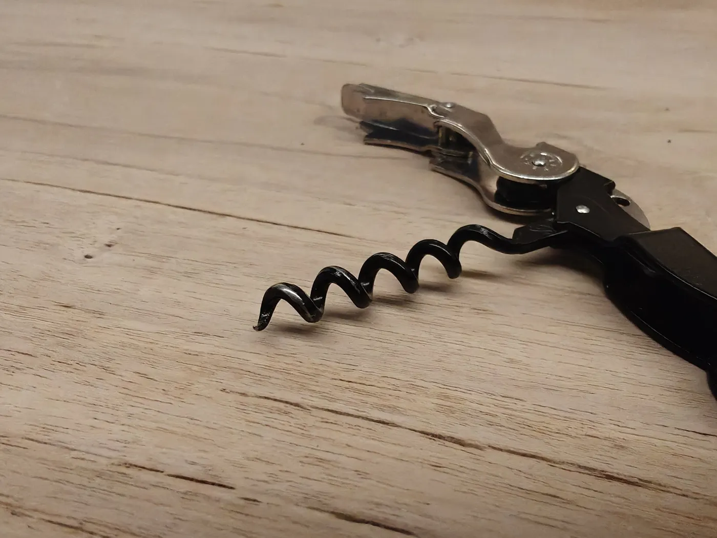 Een kurkentrekker op een tafel van licht hout